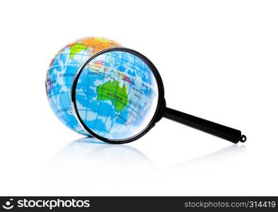 Globe under magnifying glass zooming Australia and New Zealand on white background