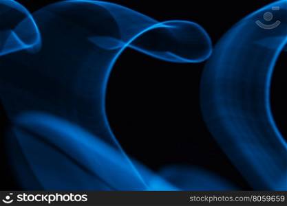 Glowing abstract curved lines.Blue colors.Black background.Done by long exposure technique.