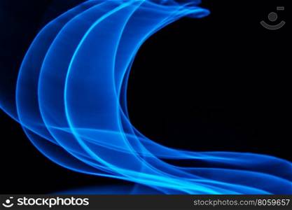 Glowing abstract curved lines.&#xA;Blue colors.&#xA;Black background.&#xA;Done by long exposure technique.