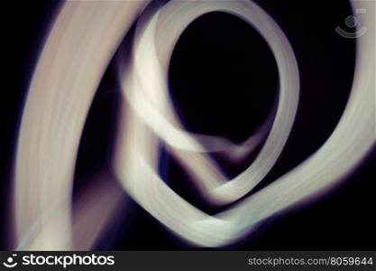 Glowing abstract curved lines.&#xA;White and blue colors.&#xA;Black background.&#xA;Done by long exposure technique