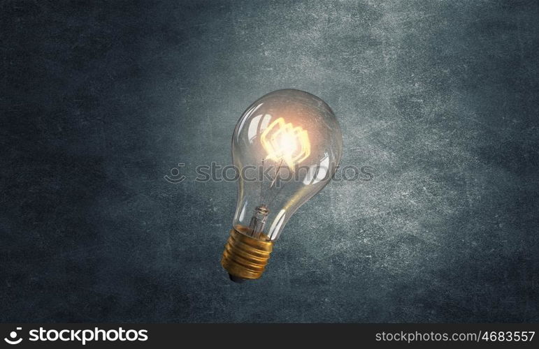 Glowing bulb. Glowing glass light bulb on dark background