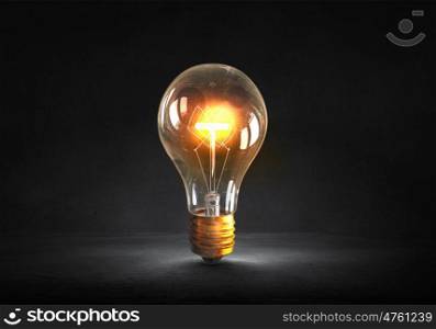 Glowing bulb. Glowing glass light bulb on dark background