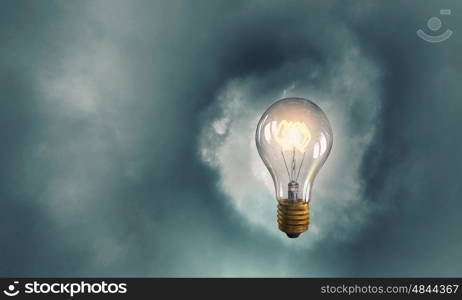 Glowing bulb. Glowing glass light bulb on dark background