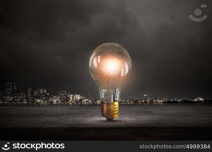 Glowing bulb. Glowing glass light bulb on dark background