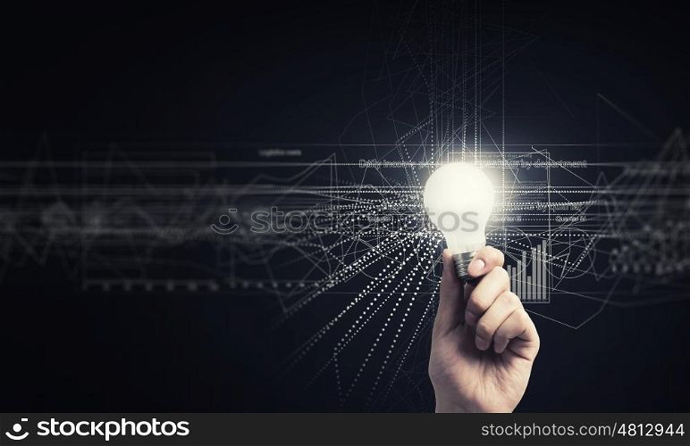 Glowing bulb in hand. Human hand holding shining electric bulb and infographs on wall