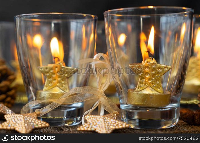 Glowing Christmas candles in glasses close up. Happy Christas and holidays concept.. Glowing Christmas candles