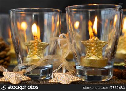 Glowing Christmas candles in glasses close up. Happy Christas and holidays concept.. Glowing Christmas candles