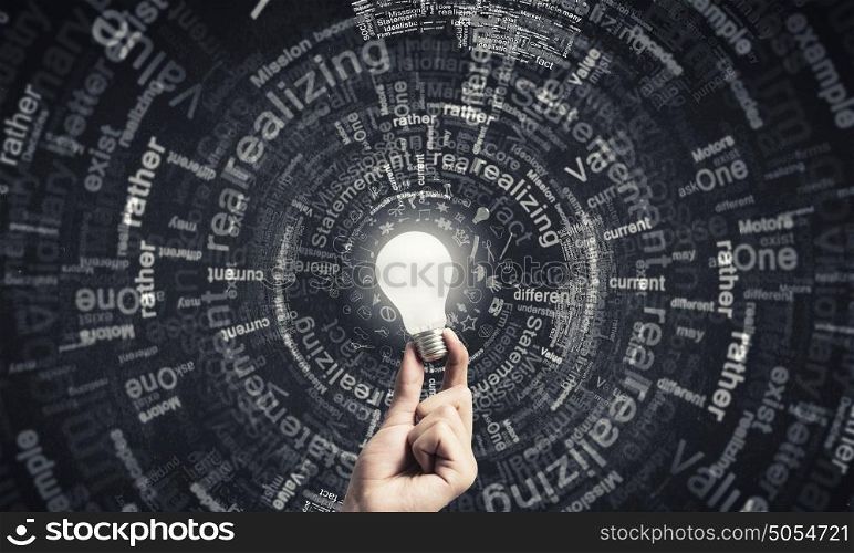 Glowing electric bulb . Hand holding glass glowing lightbulb in dark background
