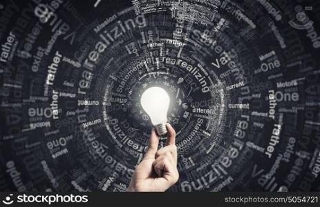 Glowing electric bulb . Hand holding glass glowing lightbulb in dark background