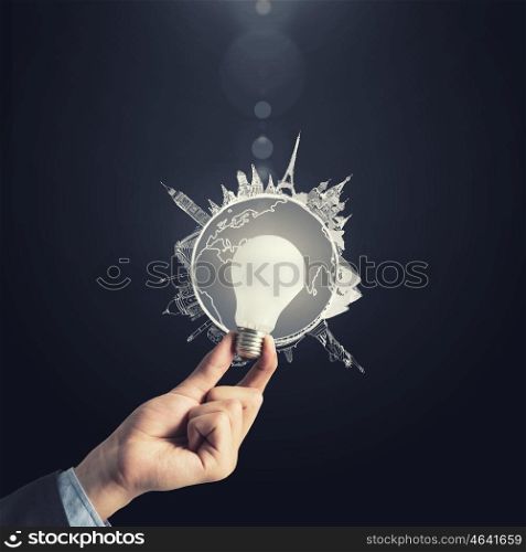 Glowing electric bulb . Hand holding glass glowing lightbulb in darkness