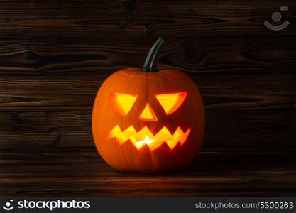 Glowing Halloween pumpkin. Glowing Halloween pumpkin head jack lantern on wooden background