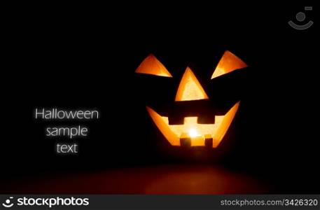 Glowing halloween scary pumpkin face on black