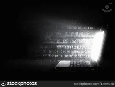 Glowing laptop. Open laptop with light coming from screen on dark background