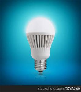 Glowing LED bulb on blue background