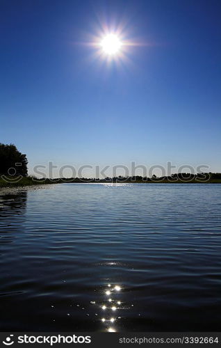 glowing sun over lake landscape