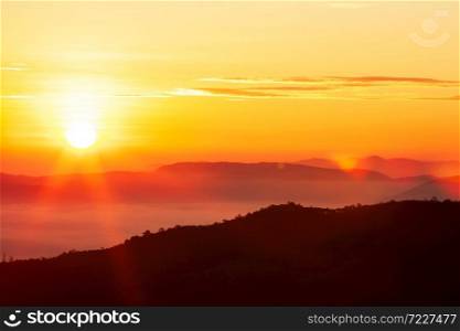 Glowing sunrise shines over mountain range, magical star shape ray from the sun with lens flare. Exploration, inspiration concept.