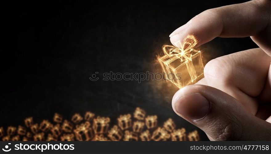 Glowing symbol between fingers. Close view of male hand taking house sign with fingers