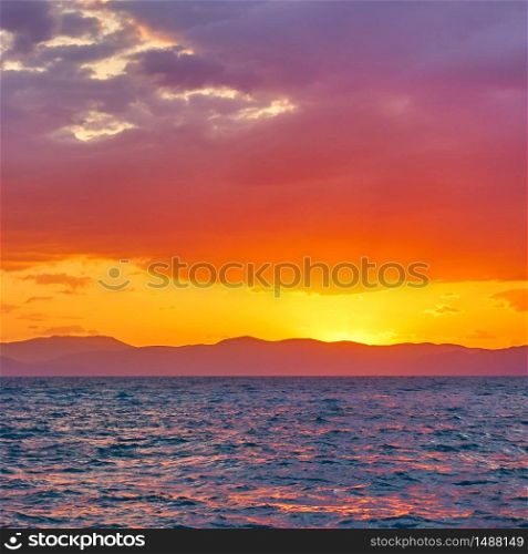 Glowing yellow red sky with clouds aloft the sea at sunset - Colorful landscape - seascape