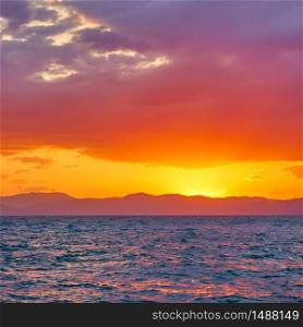 Glowing yellow red sky with clouds aloft the sea at sunset - Colorful landscape - seascape