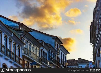Glows and reflections over old colonial style houses with their balconies in the traditional historic town of Ouro Preto during sunset. Glows and reflections over old colonial style houses