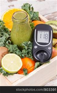 Glucometer and fresh smoothie from fruits with vegetables containing natural minerals. Diabetes and healthy eating concept. Glucometer and smoothie from fruits with vegetables containing minerals. Diabetes and healthy eating concept