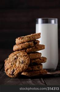 Gluten free oatmeal chocolate cookies with glass of milk on a old wooden background
