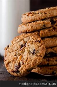 Gluten free oatmeal chocolate cookies with glass of milk on a old wooden background
