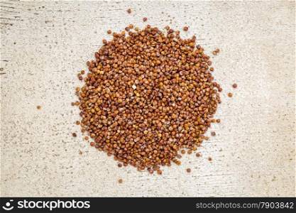 gluten free red quinoa grain - top view against rustic white painted barn wood