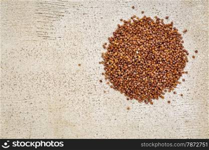 gluten free red quinoa grain - top view against rustic white painted wood