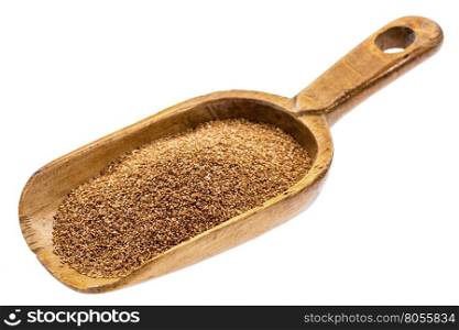 gluten free teff grain on a rustic wooden scoop, isolated on white