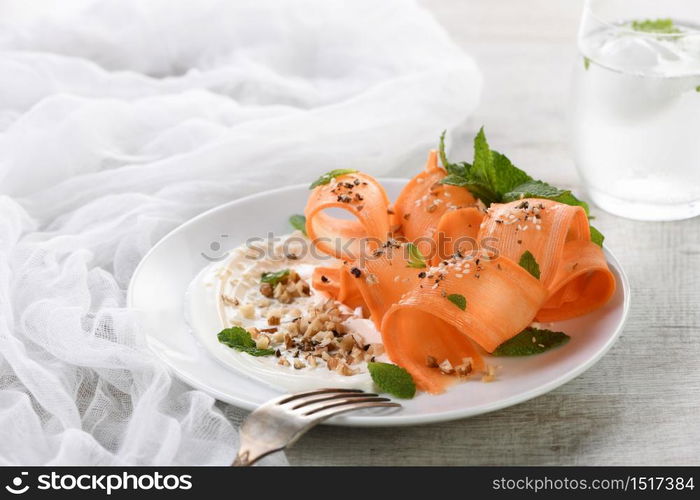 Gluten free vegetarian salad with carrot and yogurt seasoned with crushed nuts and spices, mint castings