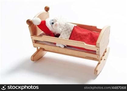 Gnome sleeping in wooden cradle isolated on white background