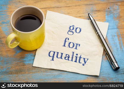 Go for quality advice or reminder - handwriting on a napkin with a cup of espresso coffee