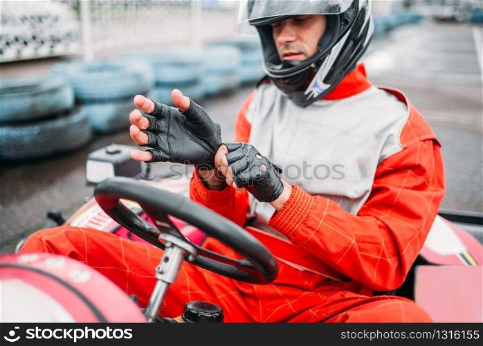 Go-kart driver in helmet on karting speed track. Carting race