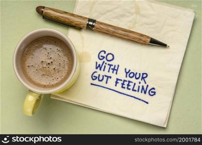 go with your gut feeling - advice or motivational reminder on a napkin with cup of coffee, instinct, intuition and personal development concept