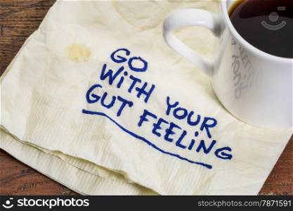 go with your gut feeling - advice or motivational reminder on a napkin with cup of espresso coffee