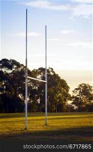 Goal posts for football, rugby union or league on field at sunset