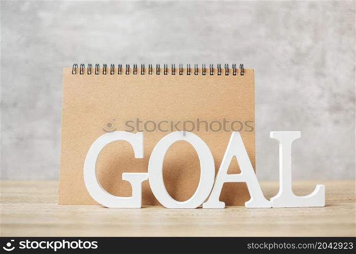 GOAL text with notebook on wood table. Motivation, Resolution, To do list, Strategy and Plan concept