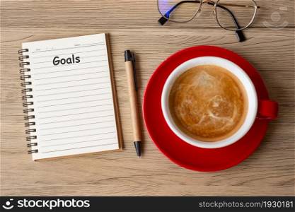 GOAL with notebook and coffee cup on wood table. Motivation, Resolution, To do list, Strategy and Plan concept