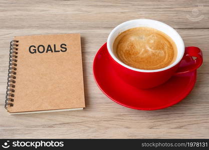 GOAL with notebook and coffee cup on wood table. Motivation, Resolution, To do list, Strategy and Plan concept