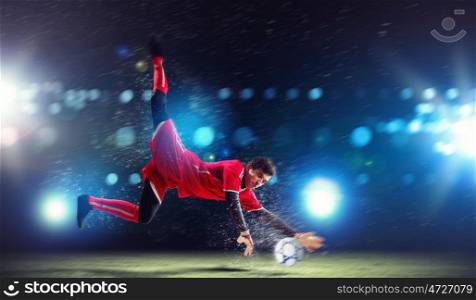 Goalkeeper catches the ball . At the stadium, in the spotlight.