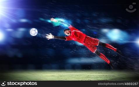 Goalkeeper catches the ball . At the stadium, in the spotlight.