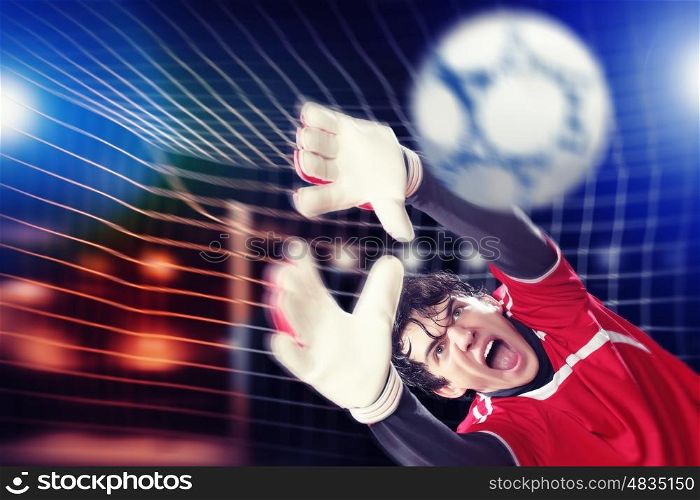Goalkeeper catches the ball. Goalkeeper catches the ball . At the stadium, in the spotlight.