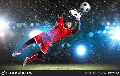 Goalkeeper catches the ball. Goalkeeper catches the ball . At the stadium, in the spotlight.