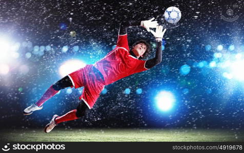 Goalkeeper catches the ball. Goalkeeper catches the ball . At the stadium, in the spotlight.