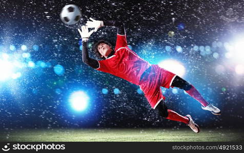 Goalkeeper catches the ball. Goalkeeper catches the ball . At the stadium, in the spotlight.