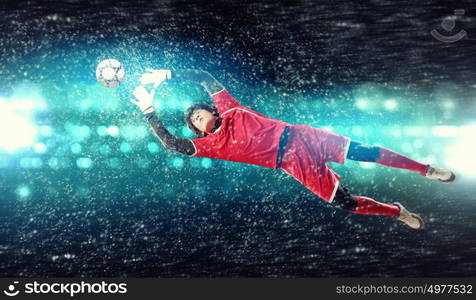 Goalkeeper catches the ball. Goalkeeper catches the ball . At the stadium, in the spotlight.