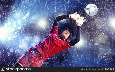 Goalkeeper catches the ball. Goalkeeper catches the ball . At the stadium, in the spotlight.