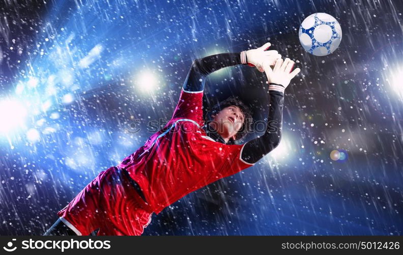 Goalkeeper catches the ball. Goalkeeper catches the ball . At the stadium, in the spotlight.