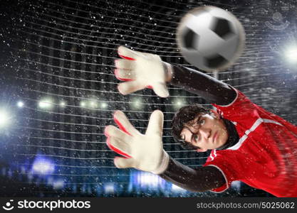 Goalkeeper catches the ball. Goalkeeper catches the ball . At the stadium, in the spotlight.